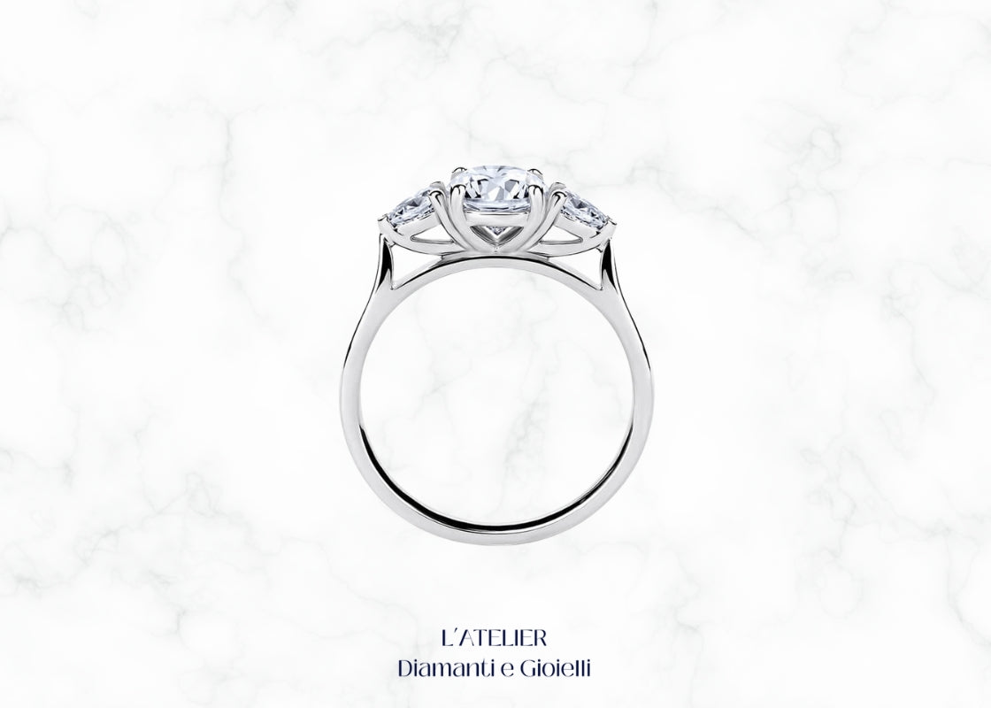 Elegante anello in oro 18 carati con diamanti taglio goccia centrali e fascia con pavé di diamanti. Gioiello lussuoso e distintivo.