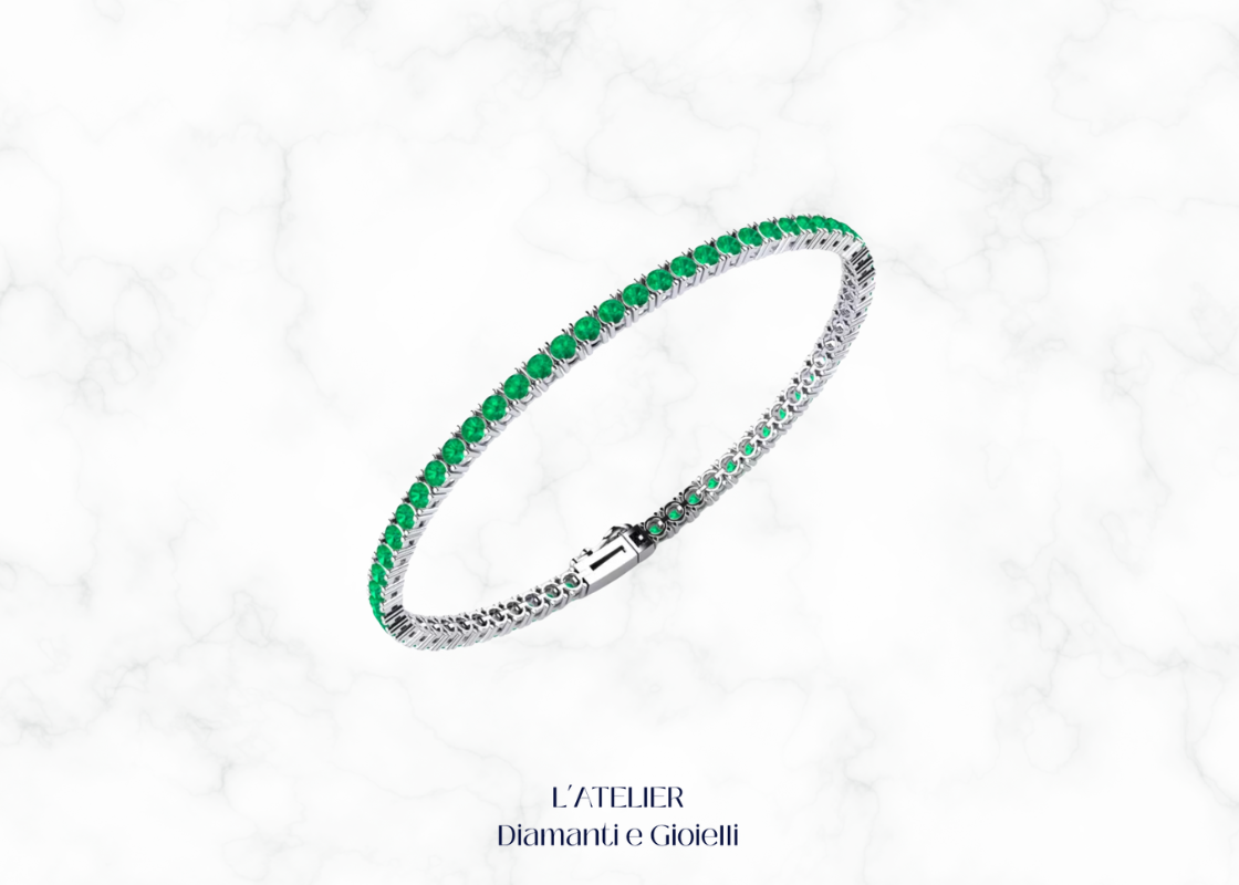 Bracciale tennis con smeraldi verdi e altre pietre preziose, su sfondo scuro. Gioiello di lusso con smeraldi di Atelier Diamanti e Gioielli