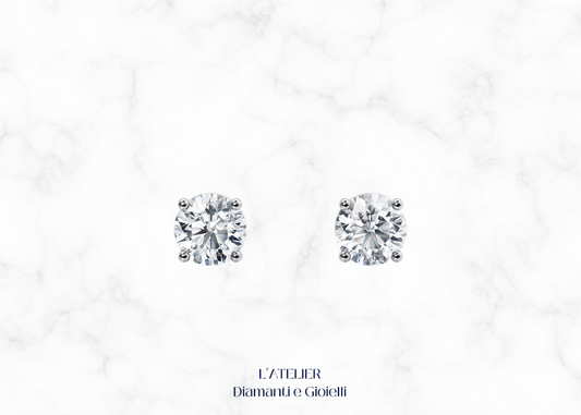 Primo piano sulla montatura a griffe di orecchini punto luce diamante Colore F Purezza VS1. Dettaglio gioiello oro 18k.