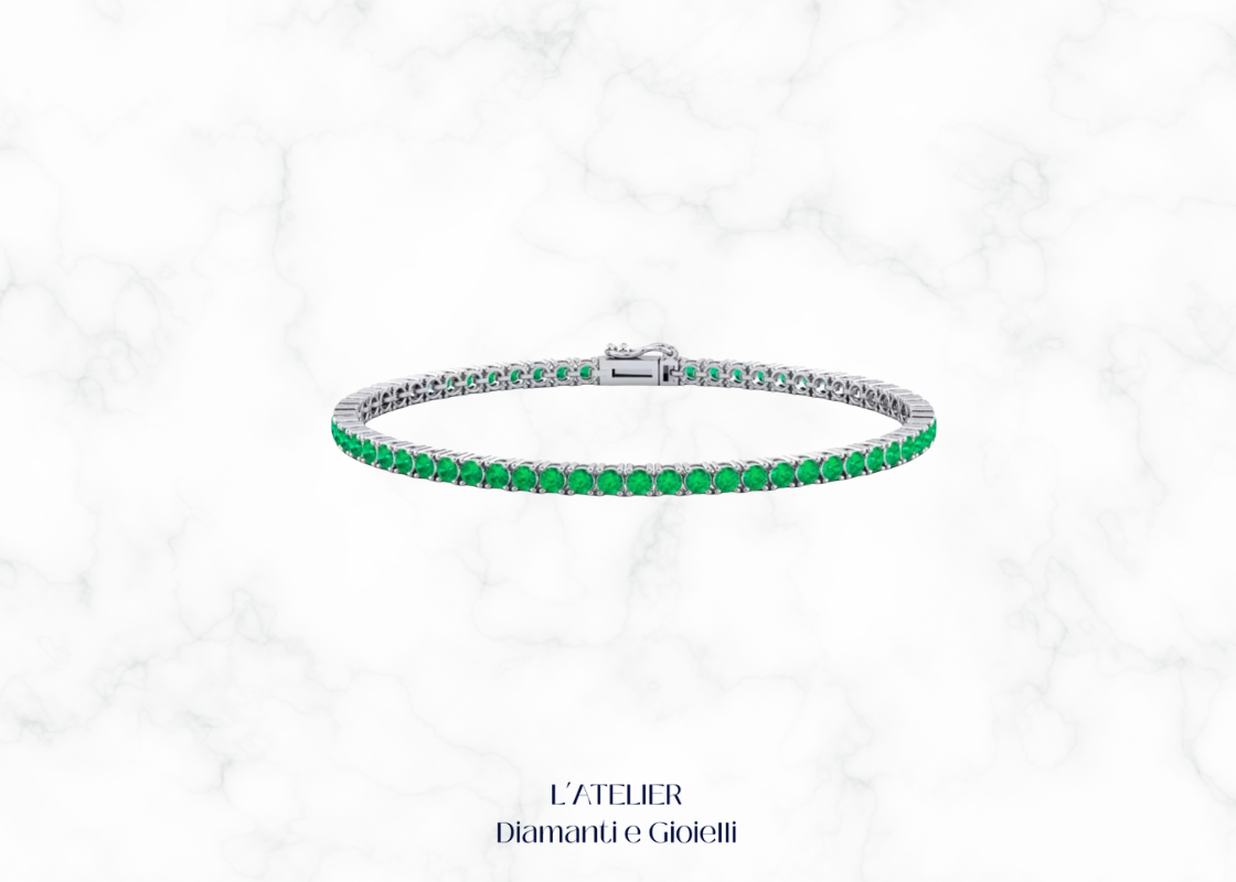 Bracciale tennis con smeraldi verdi e altre pietre preziose, su sfondo scuro. Gioiello di lusso con smeraldi di Atelier Diamanti e Gioielli