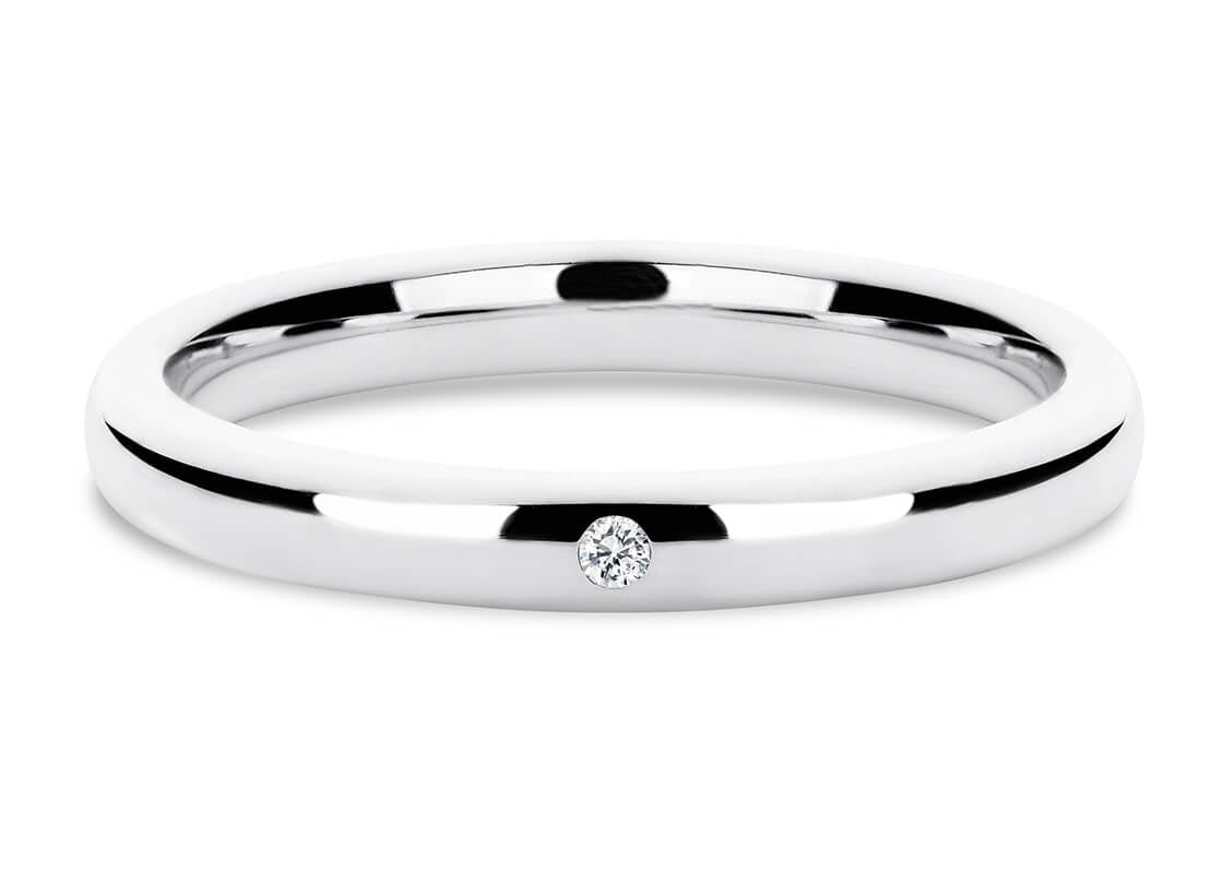 Fede nuziale in oro bianco o platino con un diamante, ambientata a Roma. Anello elegante per matrimonio di Atelier Diamanti.