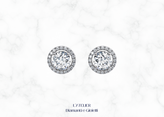 Eleganti orecchini halo in oro 18 carati con diamante centrale circondato da un pavé di diamanti più piccoli. Gioielli di lusso e raffinatezza