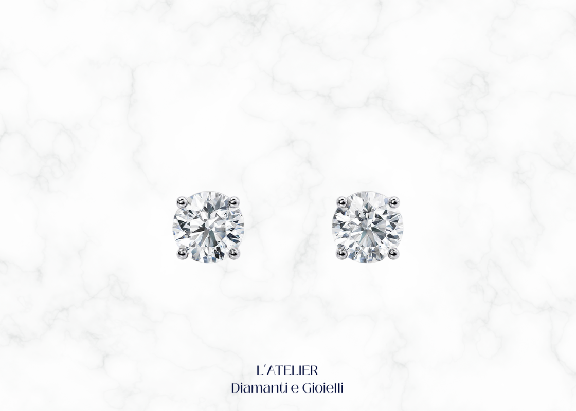 Primo piano sulla montatura a griffe di orecchini punto luce diamante Colore F Purezza VS1. Dettaglio gioiello oro 18k.
