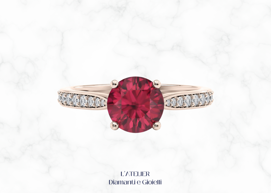 Anello di fidanzamento in Oro 18kt con Rubino Naturale rotondo in castone a griffe e Diamanti Naturali incastonati a pavé sul gambo.