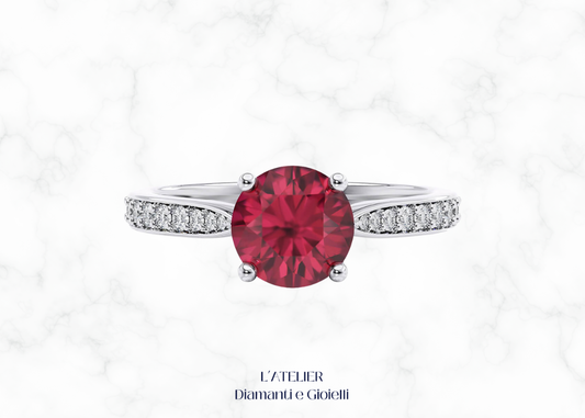 Anello di fidanzamento in Oro 18kt con Rubino Naturale rotondo in castone a griffe e Diamanti Naturali incastonati a pavé sul gambo.