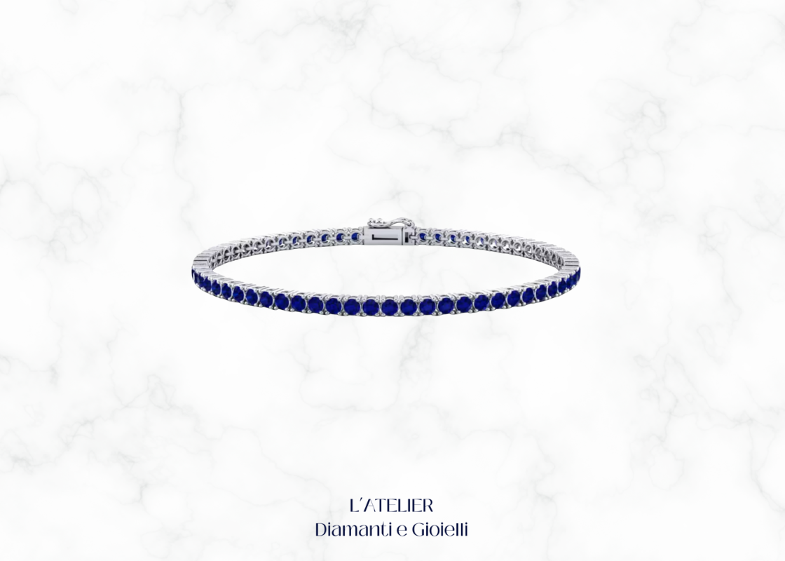 Bracciale modello tennis in oro bianco o platino con zaffiri blu e altre pietre preziose, su sfondo scuro. Gioiello di lusso Atelier Diamanti